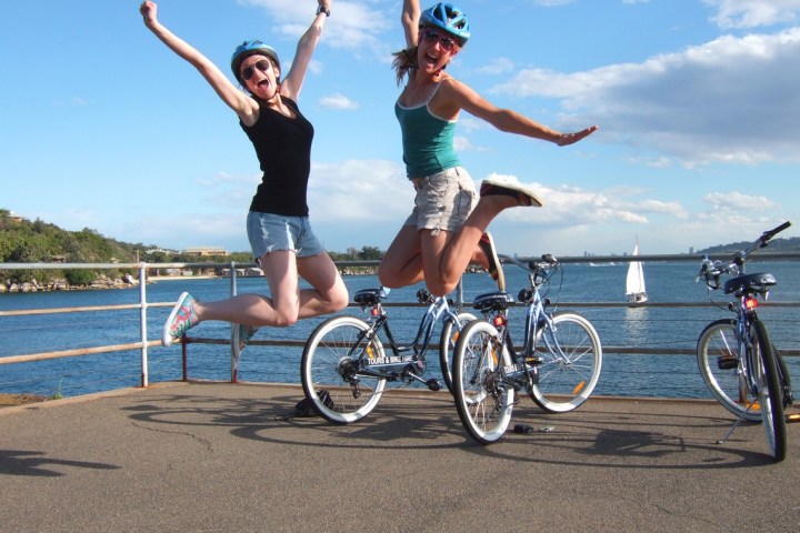 Two woman jumping and posing for a picture.