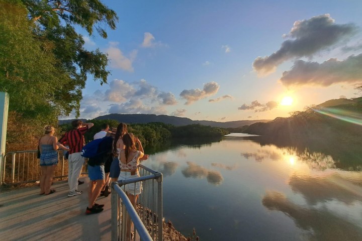 a group of people standing next to a body of water