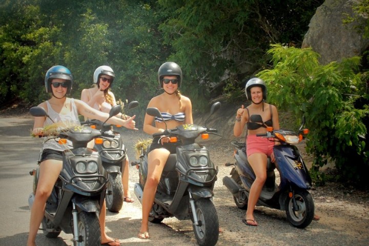 a group of people riding on the back of a motorcycle