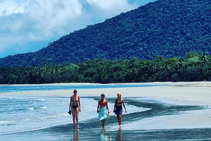 a group of people on a beach near a body of water